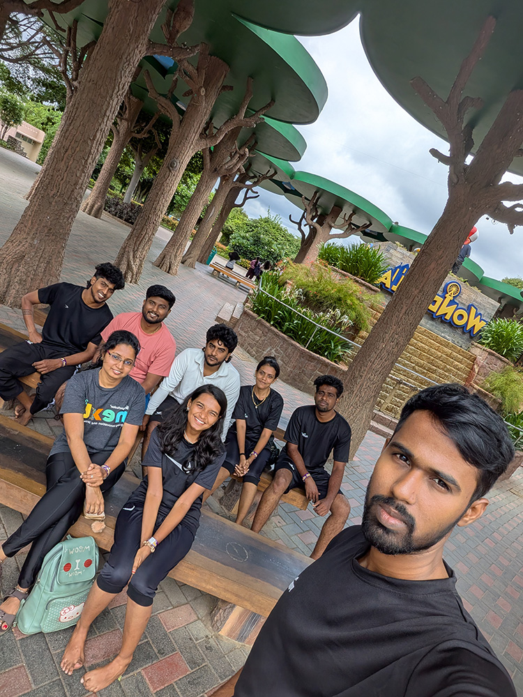 Team members sitting together on benches during a day out at a theme park